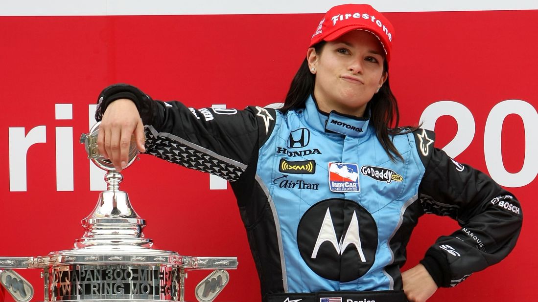 Here she poses with the trophy after winning the Bridgestone Indy Japan 300 Mile in 2008 in Japan, making her the first woman in history to win an IndyCar race.