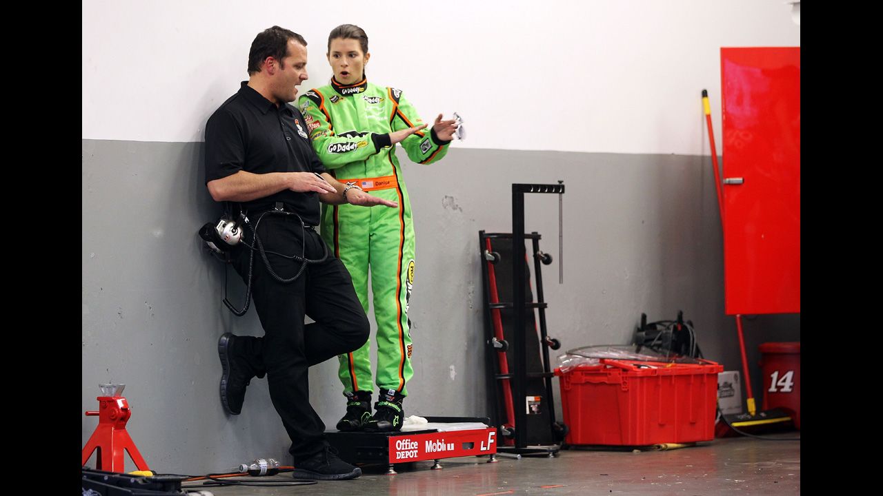 Patrick speaks to a crew member in the garage at Daytona International Speedway in 2012.