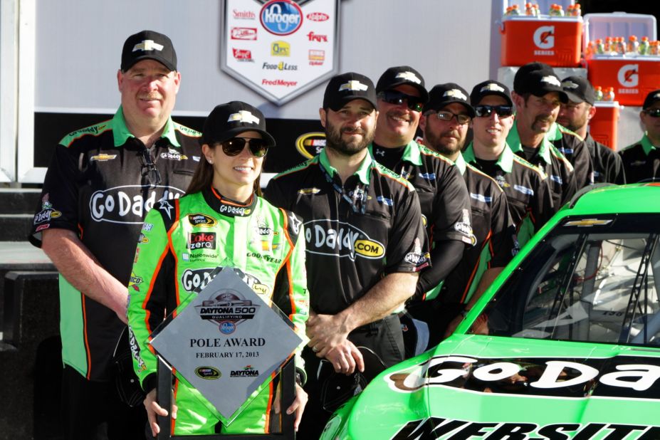 The 33-year-old holds the trophy with her crew after winning the pole award for the NASCAR Sprint Cup Series Daytona 500 in February 2013, again making her the first woman to do so.