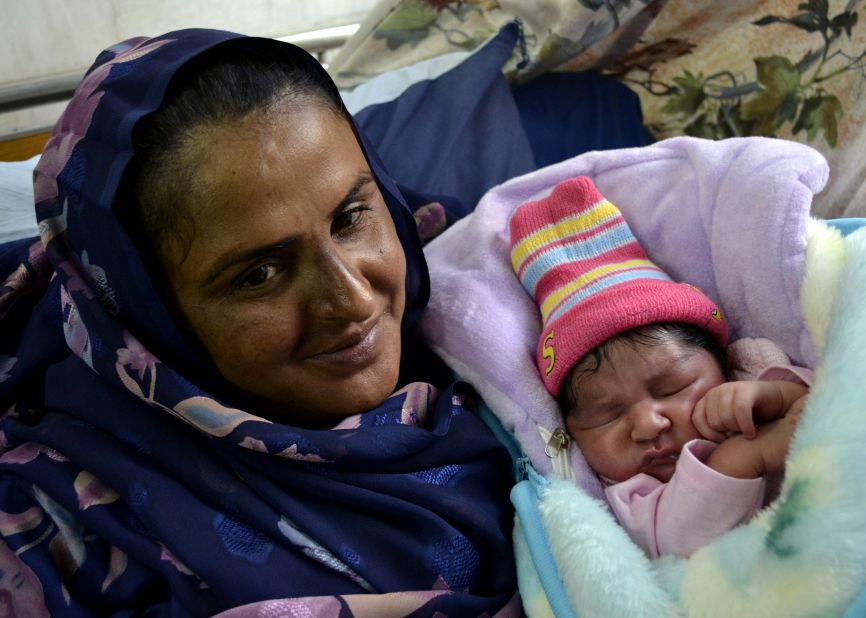 Mukhtar Mai smiles next to her new born baby boy at a hospital in Multan on December 5, 2011.