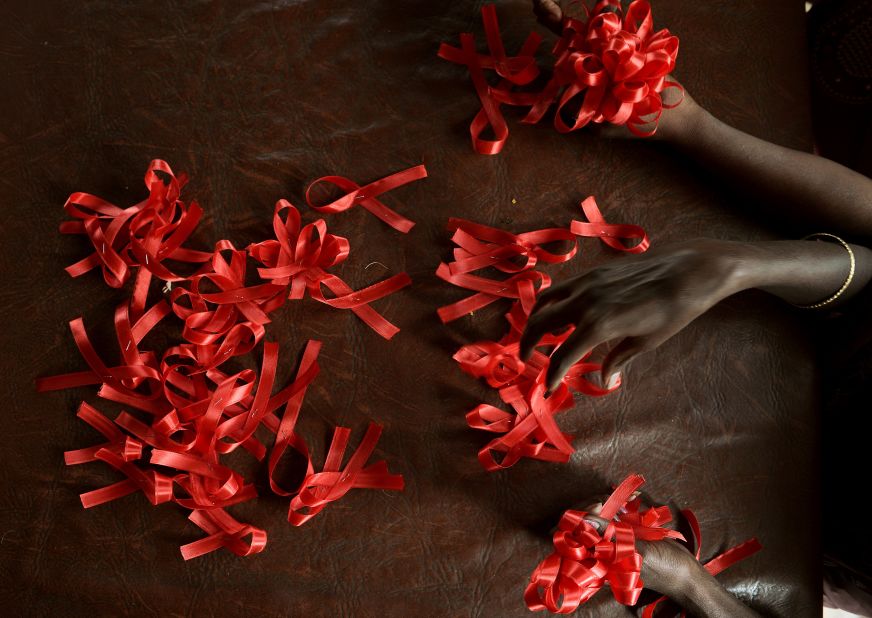 HIV positive women make red ribbons, the universal symbol of awareness and support for those living with HIV, at a support center in Bangalore on the eve of World AIDS Day on November 30, 2012.