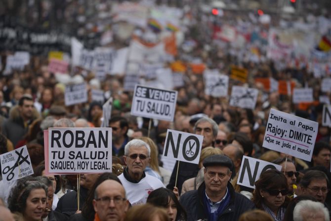 Protesters hold placards as they take part in a demonstration against plans to cut medical spending and privatize hospital services in Madrid on February 17. 