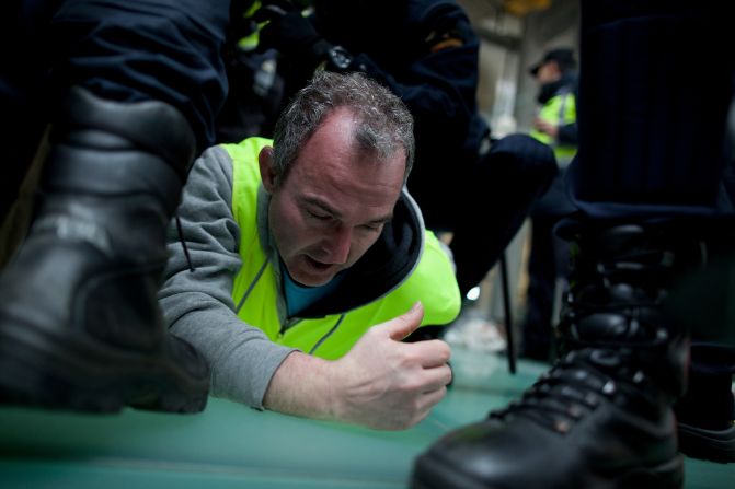 Policemen arrest a Spanish Airline Iberia worker during a protest against job cuts at Barajas Airport on February 18 in Madrid, Spain. 