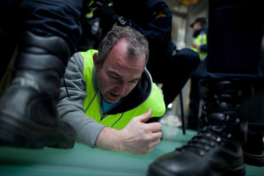 Policemen arrest a Spanish Airline Iberia worker during a protest against job cuts at Barajas Airport on February 18 in Madrid, Spain. 