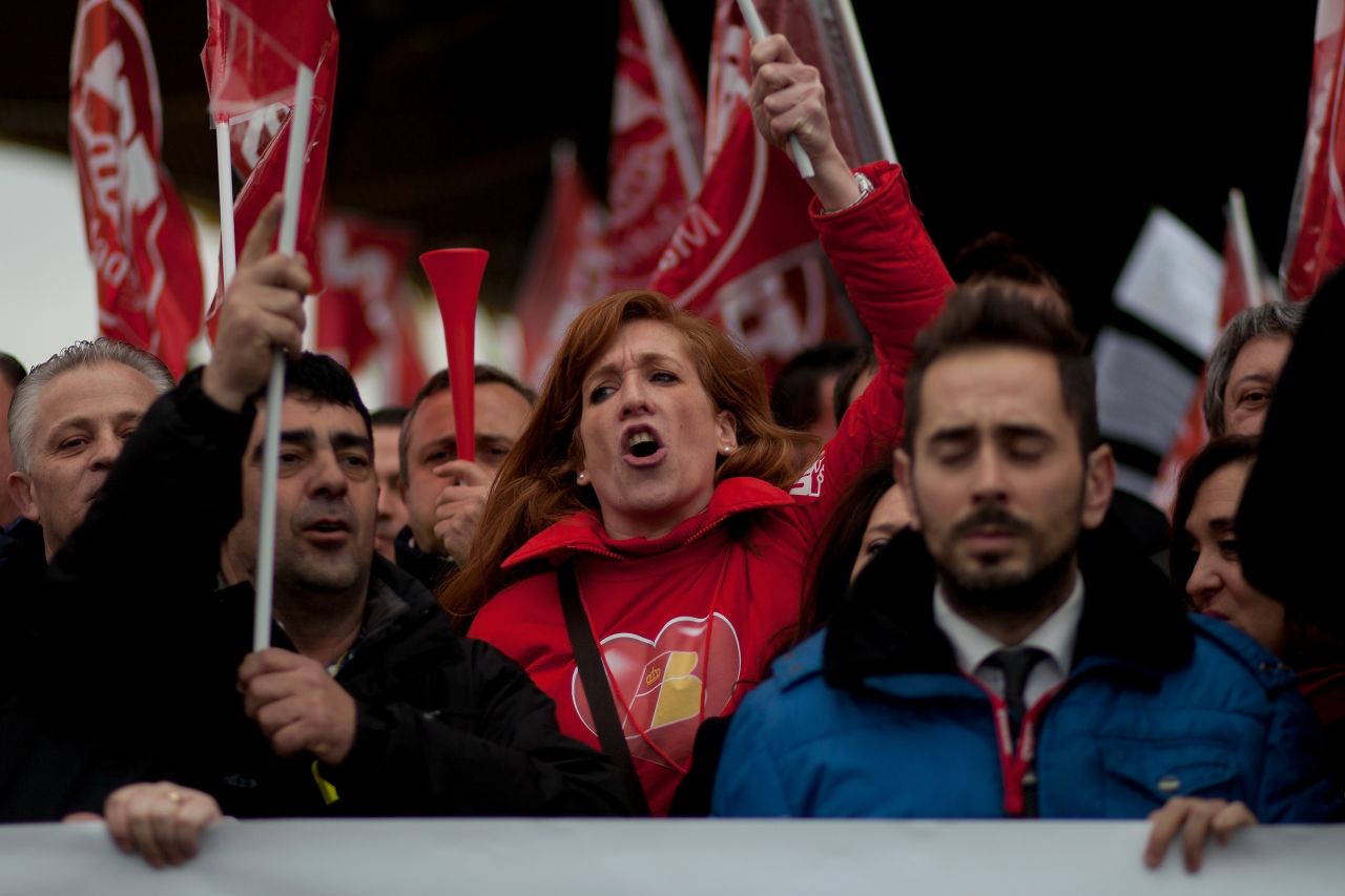 Staff from Spanish Airline Iberia hold flags and gather in protest against job cuts.