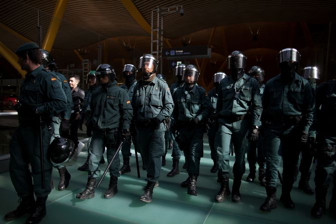 Riot Police walk forward making a cordon during a protest of Spanish Airline Iberia staff.