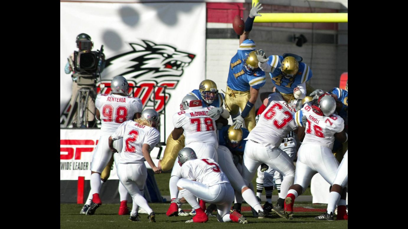 University of New Mexico kicker Katie Hnida, No. 2, attempts an extra point against UCLA in the Las Vegas Bowl on December 25, 2002, becoming the first woman to play in a Division I-A football game. The kick was blocked, but she later became the first woman to score points in college football's top division. 