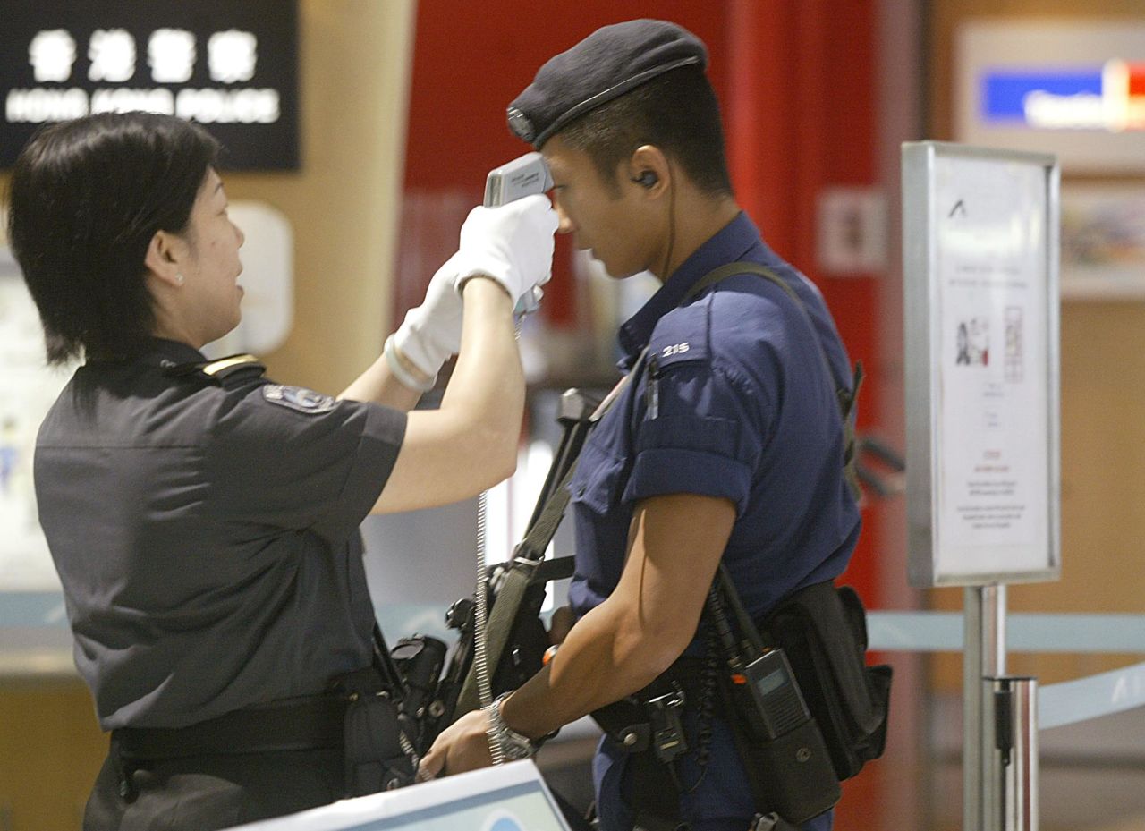 Airport police have their temperature checked before entering the restricted area at Hong Kong International Airport, September 9,  2003. 