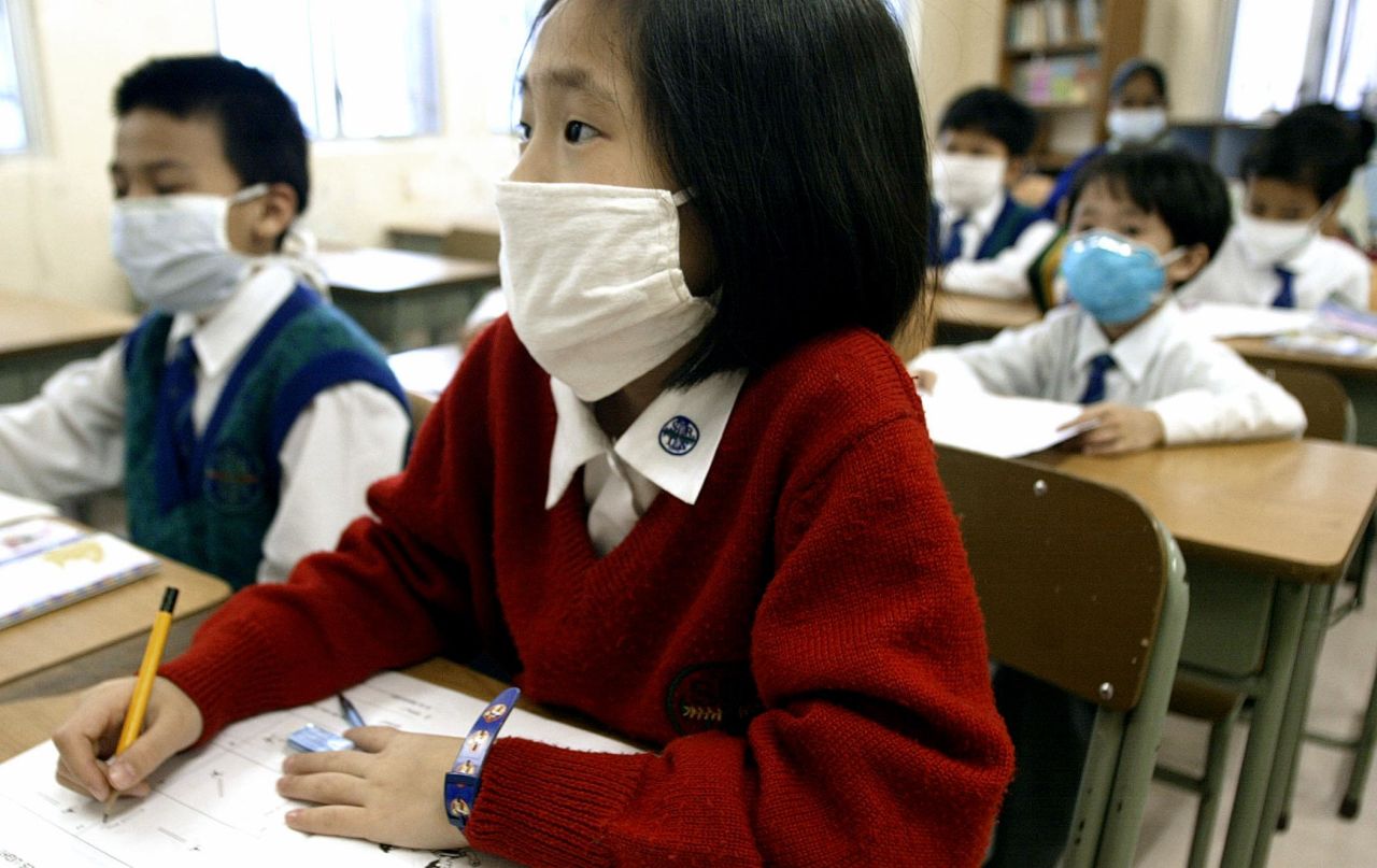 Hong Kong schoolchildren wear masks in their classroom, March 28, 2003.