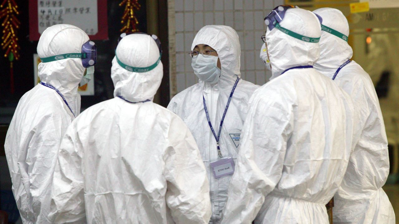 Health workers stand outside Block E of Amoy Gardens on April 8, 2003 in Hong Kong. 