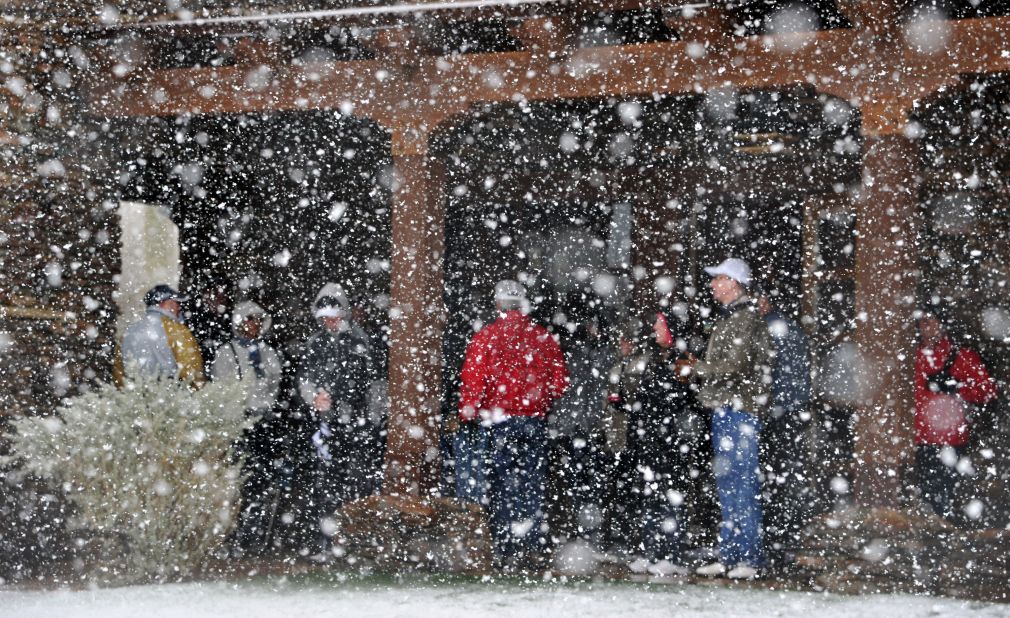 Golf fans seek shelter from the snow Wednesday after the first round of the Accenture Match Play Championship at Dove Mountain in Marana, Arizona. The tournament was suspended due to the weather.