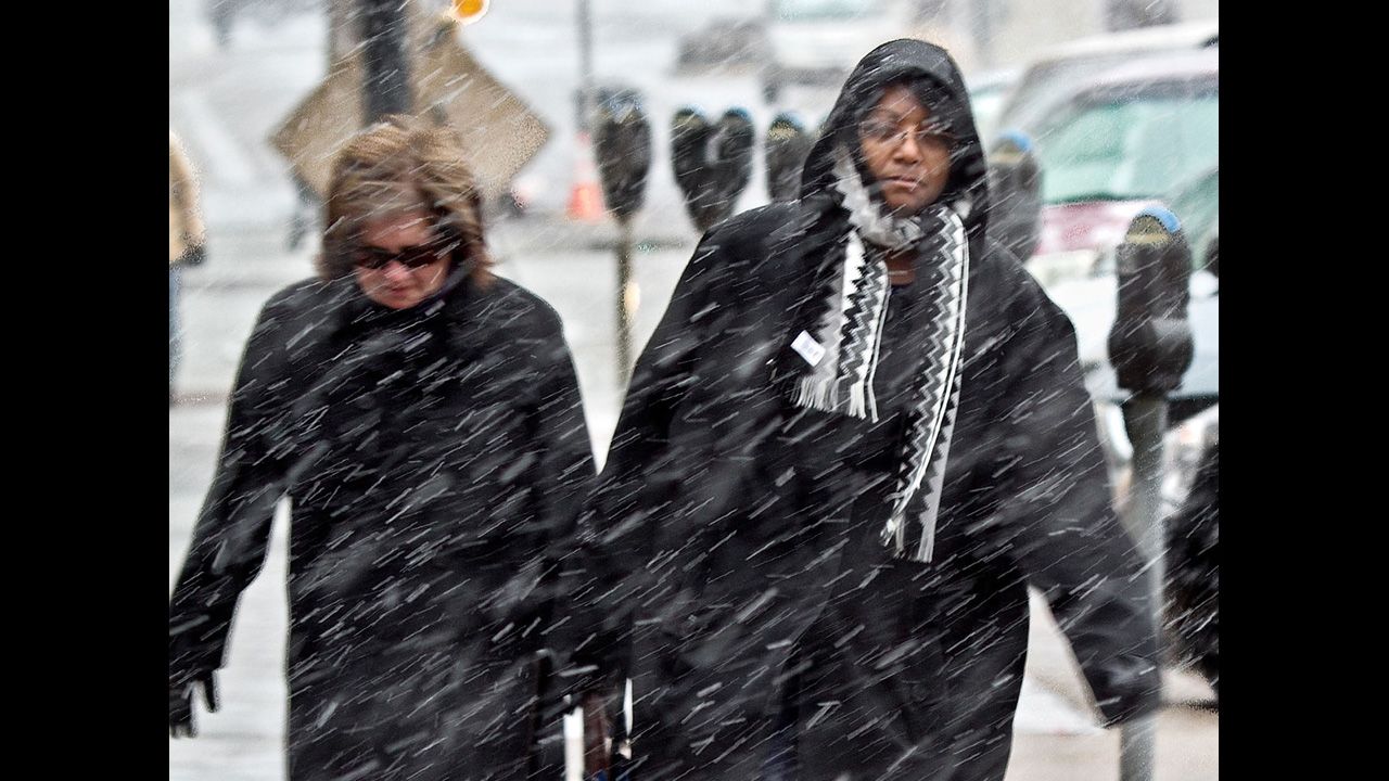 Pedestrians make their way to work through the snow in downtown Wichita, Kansas, on Wednesday, February 20. 