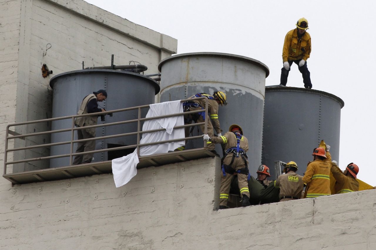 A team works to remove the body. The body of Elisa Lam, 21, of Vancouver, Canada was found in the Cecil Hotel's rooftop water tank by a maintenance worker who was trying to figure out why the water pressure was low on Tuesday.