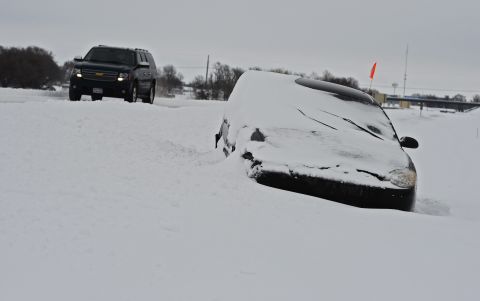 A car is stranded in the snow on Highway 135 outside Wichita, Kansas, on Thursday, February 21.