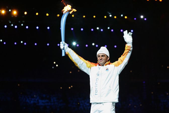 Tomba carries the Olympic torch into the stadium at the opening ceremony for the 2006 Winter Games in Turin.