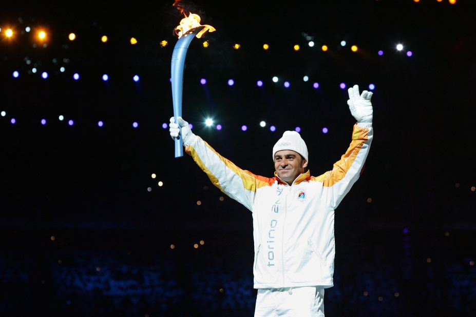 Tomba carries the Olympic torch into the stadium at the opening ceremony for the 2006 Winter Games in Turin. 