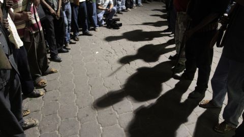 (File photo) Men stand guard while passing the detainees to the Government of the State of Guerrero on February 8, 2013.