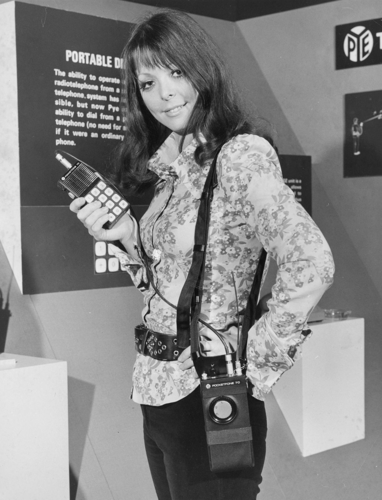 In this image from 1972, a model demonstrates a "portable radio-telephone" by Pye Telecommunications at a London exhibition called "Communications Today, Tomorrow and the Future."