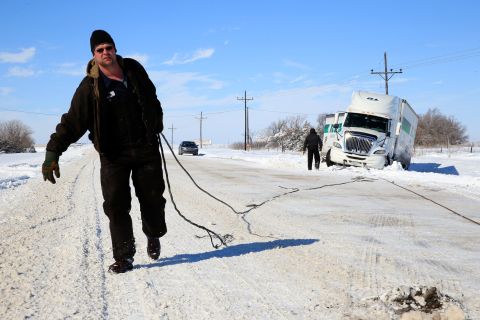 Tow truck driver Tyson House helps trucker Gary Wheeler of Kansas City on Friday, February 22, in Greensburg, Kansas, after his truck slid off the road. The huge snowstorm was moving across the Plains on Thursday.