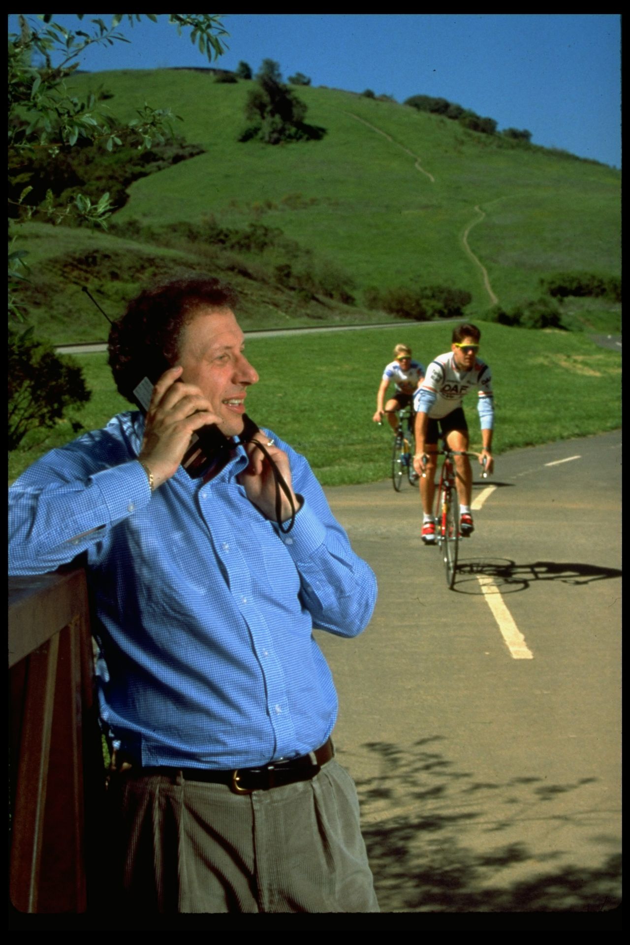 It's no iPhone. In this image from 1989, Allan Z. Loren, then-president of Apple Computer USA, talks on a mobile phone as cyclists ride past. 