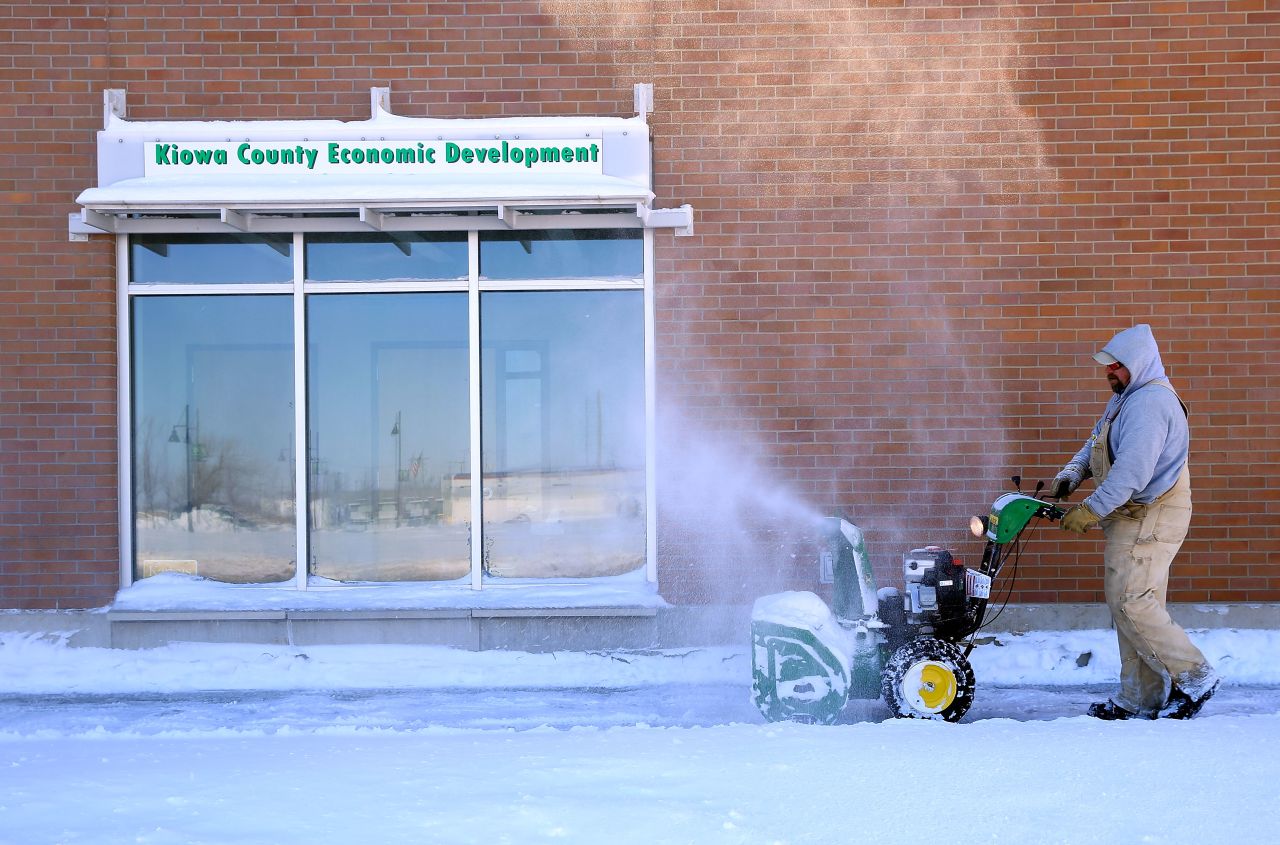 A worker uses a snowblower to clear a path on February 22 in Greensburg, Kansas.