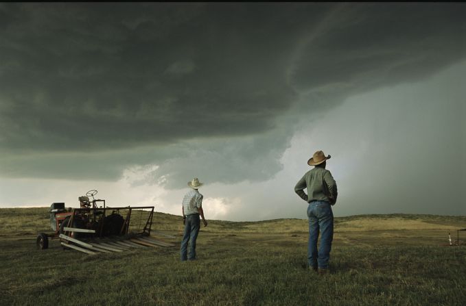 The "Greatest Photographs of the American West" exhibit is currently touring the United States. Here, workers in Nebraska halt haying to watch as afternoon thunderheads fill the sky. 