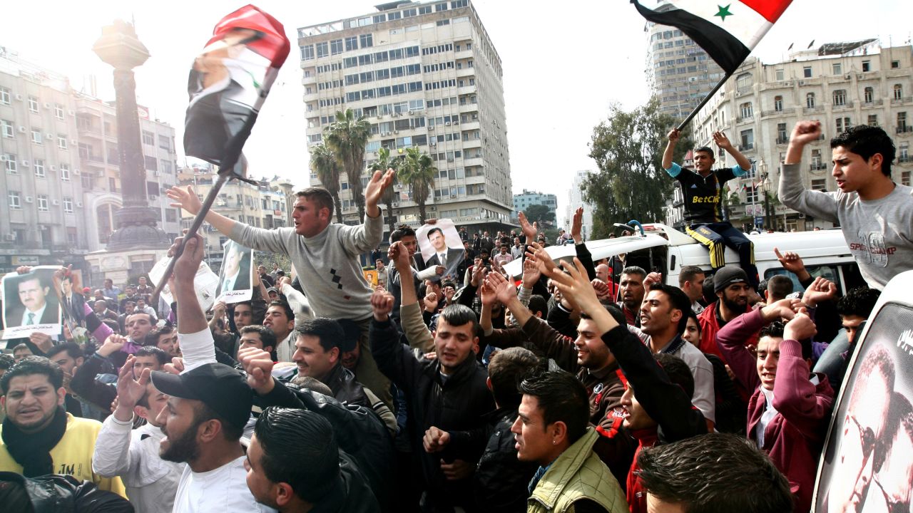Syrian protesters chant slogans in support of al-Assad during a rally in Damascus on March 25, 2011.