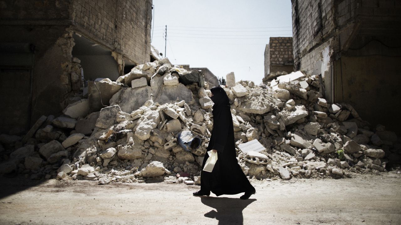 A woman walks past a destroyed building in Aleppo on September 13.