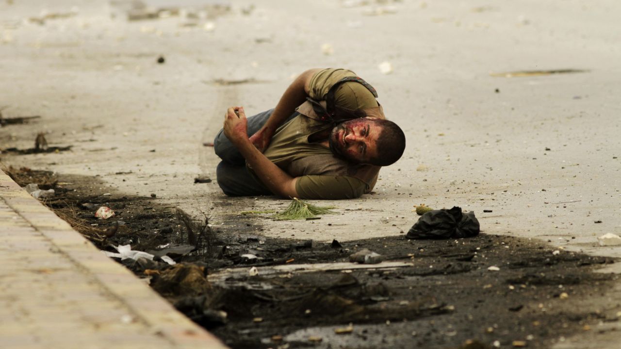 A man lies on the ground after being shot by a sniper for a second time as he waits to be rescued by members of the Al-Baraa Bin Malek Battalion, part of the Free Syria Army's Al-Fatah brigade, in Aleppo on October 20, 2012.