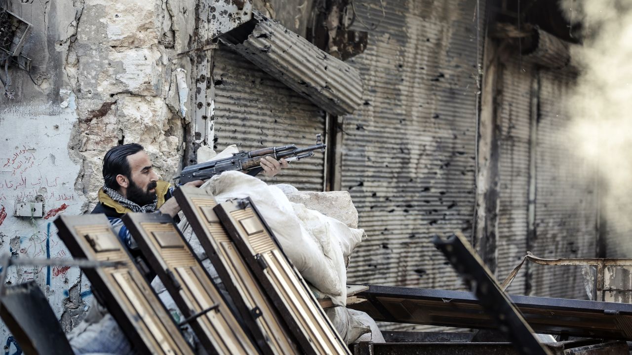 A rebel fighter fires at a Syrian government position in Aleppo on November 6, 2012.
