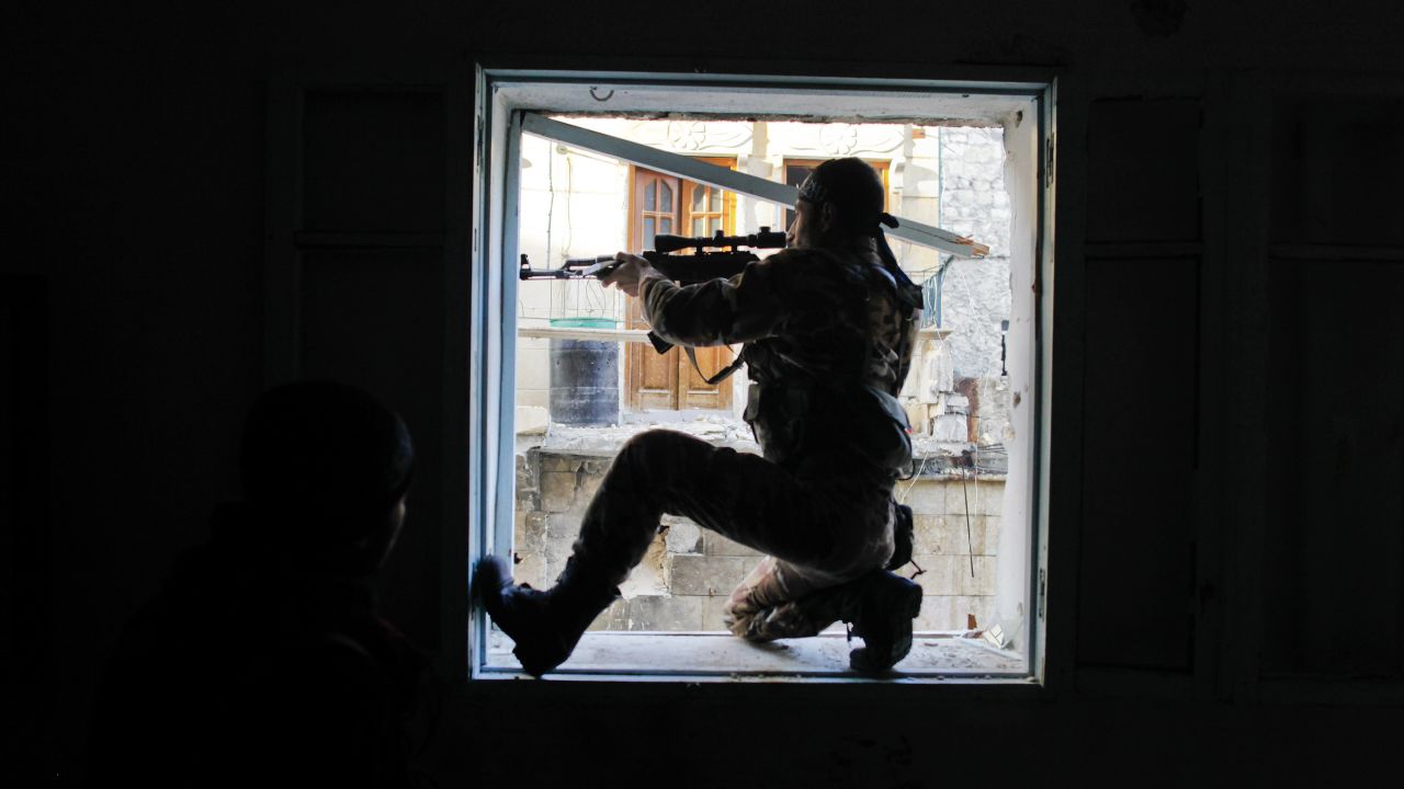 A member of Liwa Salahadin aims at a regime fighter in the besieged district of Karmel al-Jabl in Aleppo on December 6.