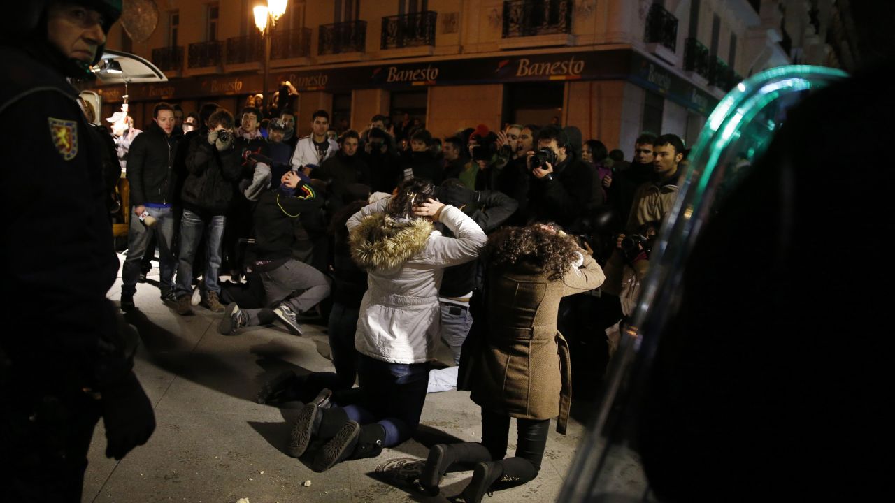Protesters face Spanish riot police at the end of the demonstration in Madrid.
