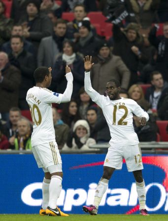 Swansea scorers Jonathan de Guzman and Nathan Dyer celebrate on their way to a 5-0 League Cup final win over Bradford at Wembley.   