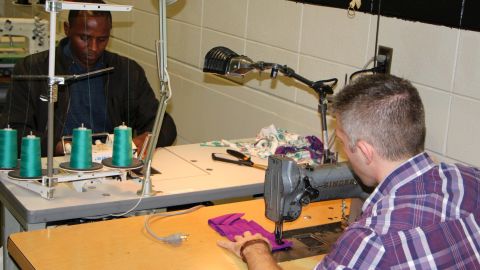 Students learn industrial cutting and sewing in a training program organized by a coalition of businesses and industry partners.