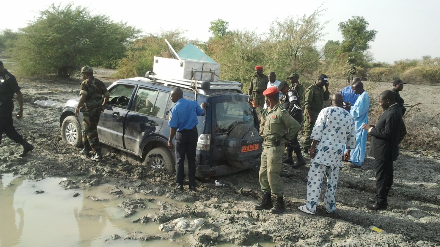Cameroonian security officials stand at the vehicle a French family was driving before being kidnapped.