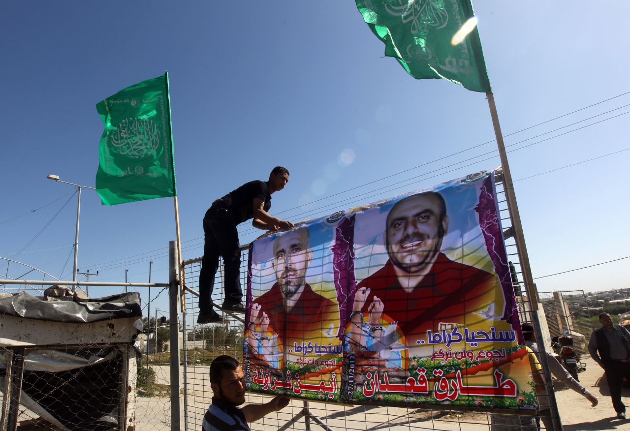 Palestinians erect posters of hunger-striking Palestinian prisoners at Erez border crossing between Israel and the northern Gaza Strip on February 26, 2013. 