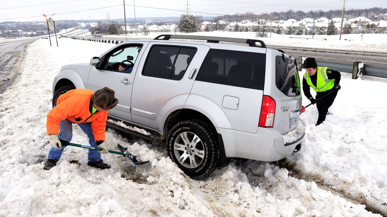 City worker Thuan Tran and police officer Christina Batalia help dig out stranded motorist Gary Cook after the area was hit by a snowstorm on February 26 in Overland Park, Kansas.  