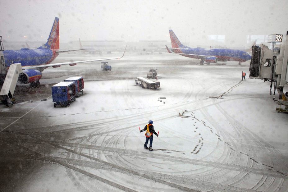 Southwest Airlines employees guide a plane into the gate at Midway International Airport in Chicago on Tuesday, February 26. Back-to-back storms have hit the Great Plains, which is still digging out from last week's weather. <em>Are you experiencing the storm? If it's safe, </em><a href="http://ireport.cnn.com/topics/877827"><em>share your photos</em></a>.