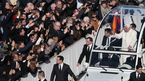 Benedict waves to the crowd as he arrives in the popemobile.