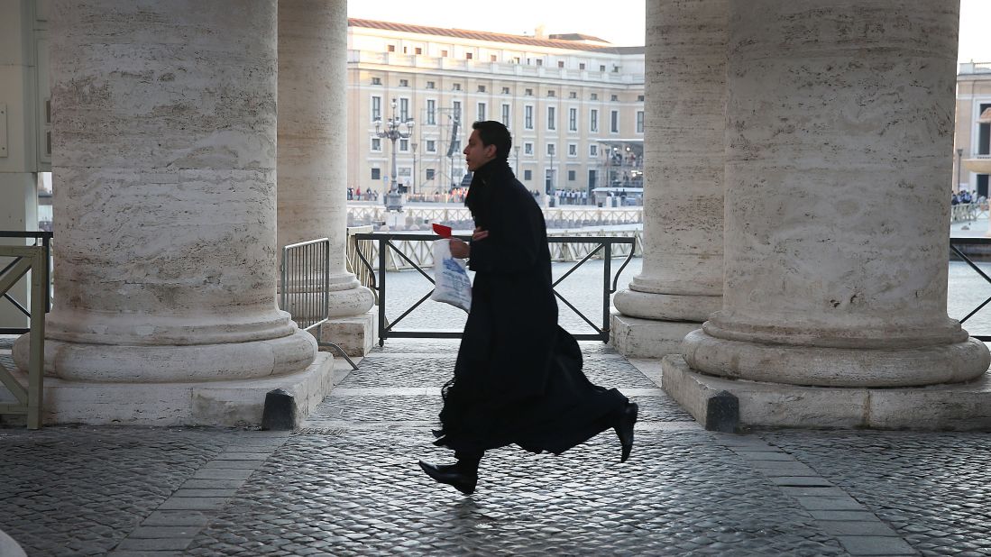 A priest runs to get into St. Peter's Square ahead of pope's last public audience address.