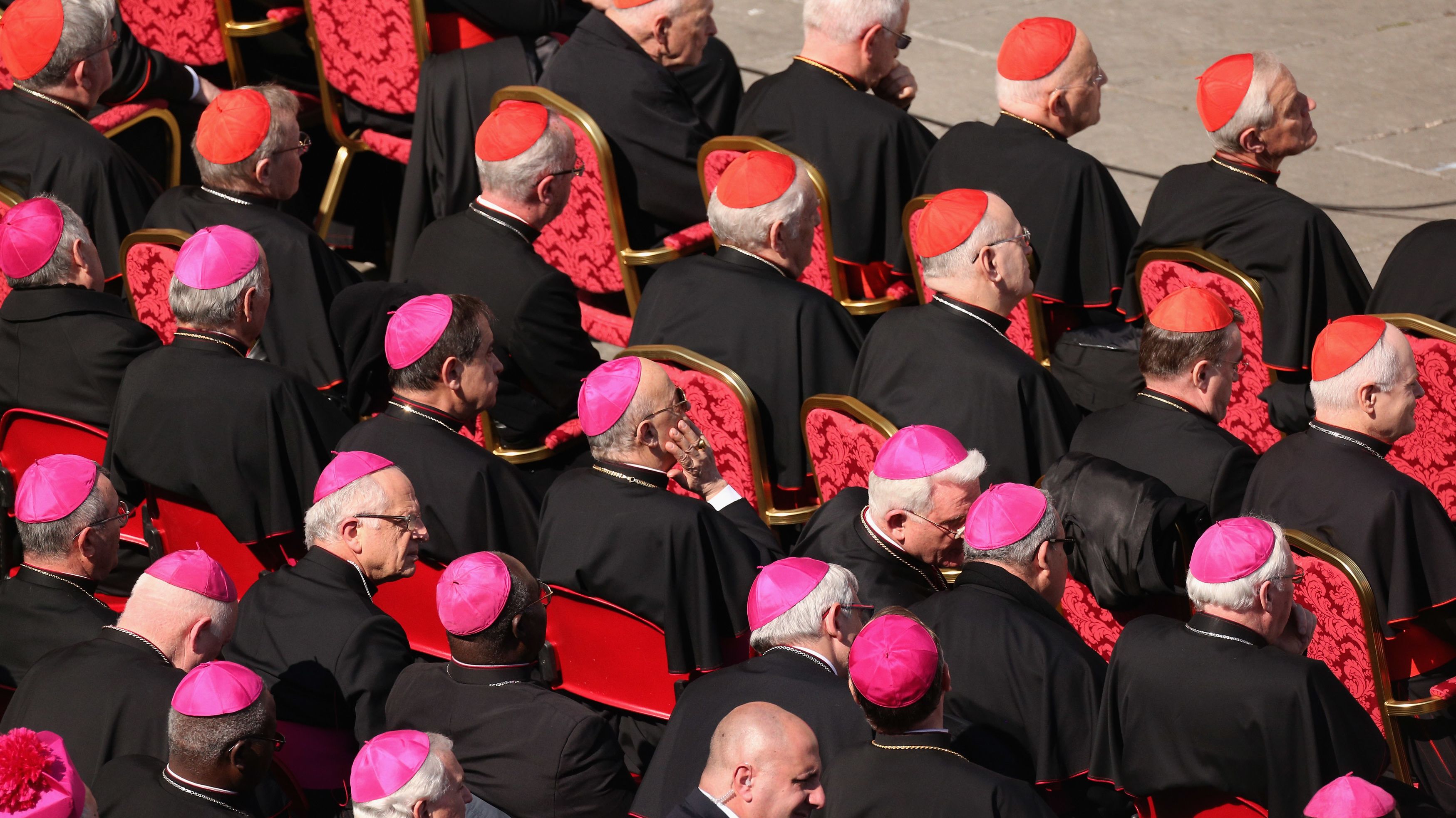  Archbishops (purple hats) and cardinals (red hats) sit in St Peter's Square on February 27 in Vatican City.
