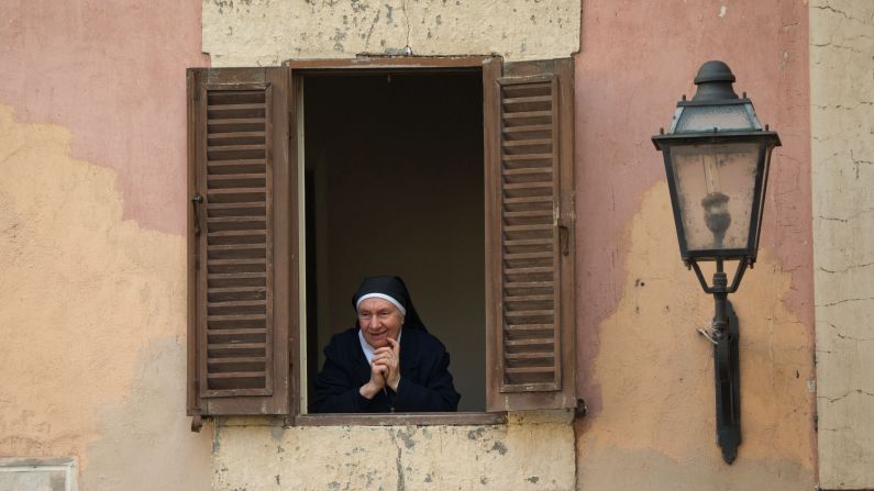 Una monja mira a través de una ventana en Castel Gandolfo.