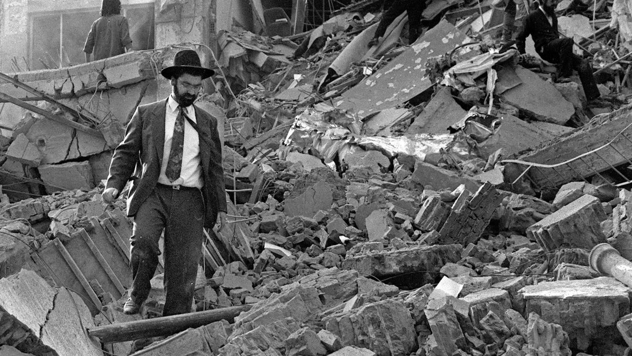 (File photo) A man walks over the rubble after a bomb exploded at the Israeli Mutual Association in Buenos Aires, 18 July 1994. 