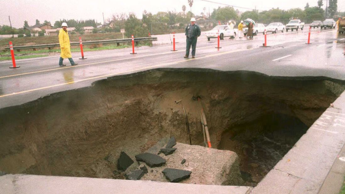 A 30-foot-deep sinkhole appeared in a busy street in a suburb east of downtown Los Angeles. A motorist drove into the hole but was rescued before a concrete slab fell onto the car.