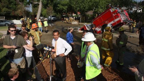 A fire truck protrudes from a sinkhole as Los Angeles Mayor Antonio Villaraigosa talks to reporters in September 2009.