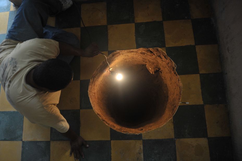 In July 2011, a man inspects a 40-foot-deep sinkhole that a family found after they heard a booming noise in their kitchen in Guatemala City, Guatemala.