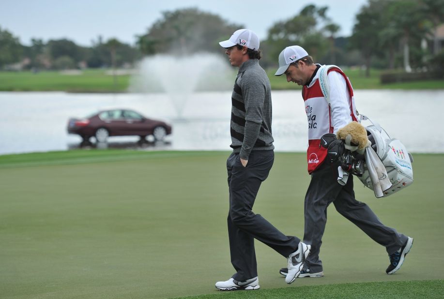 Rory McIlroy and his caddie J.P Fitzgerald walk off the course after the Northern Irish stars pulls out of the second round of the Honda Classic. 