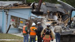 Demolition crews and Hillsborough County Fire Department watch as the house, where Jeffrey Bush was swallowed by a sinkhole, is demolished in Seffner, Florida March 3, 2013. Florida rescue workers ended their efforts on Saturday to recover the body of Jeffrey Bush, who disappeared into the sinkhole that swallowed his bedroom while he slept and demolished the suburban Tampa home due to its dangerous conditions, a rescue spokeswoman said. REUTERS/Scott Audette (UNITED STATES - Tags: DISASTER ENVIRONMENT TPX IMAGES OF THE DAY) REUTERS /SCOTT AUDETTE /LANDOV