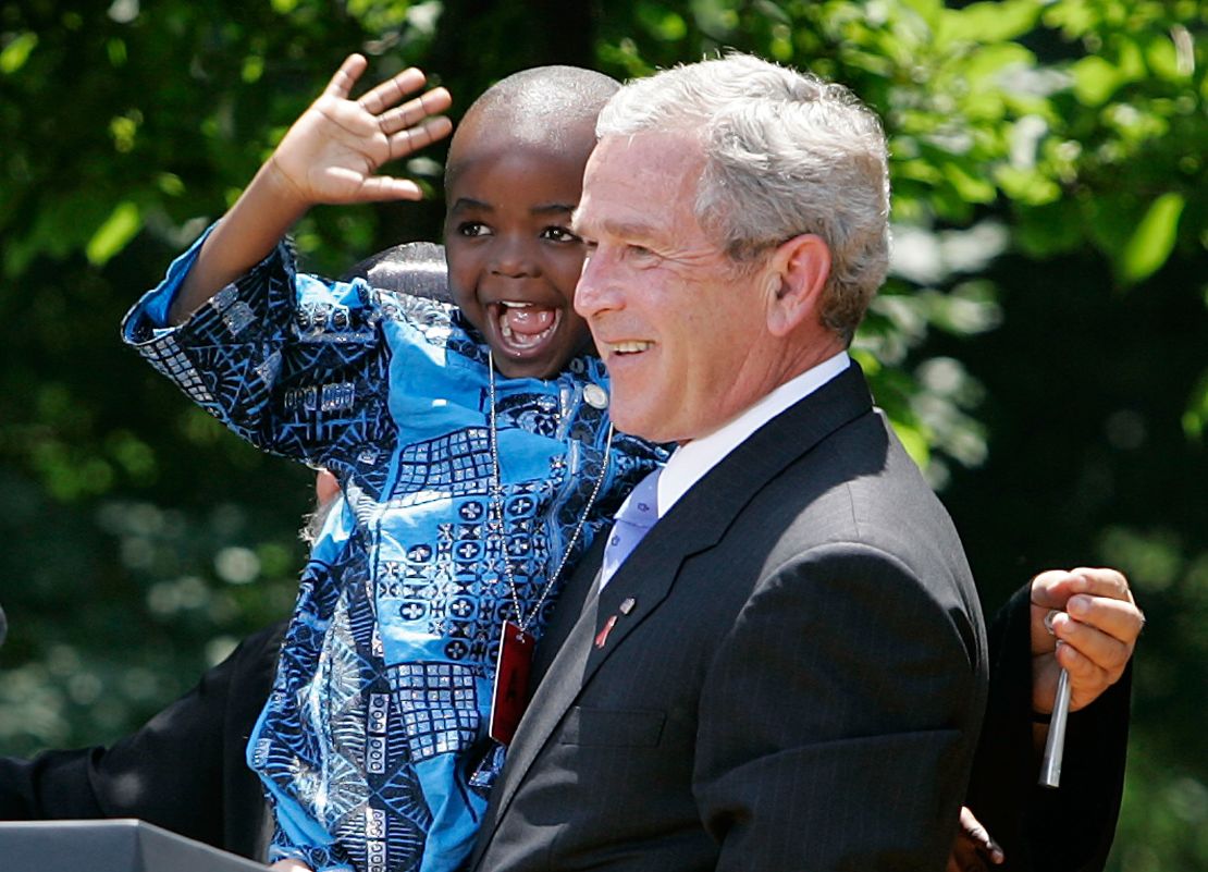 President George W. Bush holds up 4-year-old Baron Tantoh during a news conference on PEPFAR.