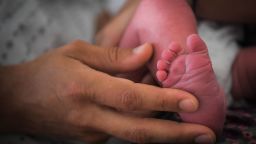 A mother holds the foot of her newborn baby on July 7, 2018 at the hospital in Nantes, western France. (Photo by LOIC VENANCE / AFP)        (Photo credit should read LOIC VENANCE/AFP via Getty Images)